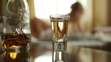 closeup bardak konyak ya da viski, kucaklayan ve öpüşme yatakta genç seksi çift. bulanık odak, bir yatak içinde belgili tanımlık geçmiş lovers