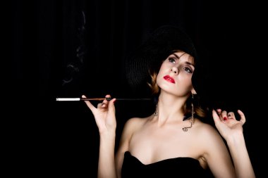 Güzellik retro kadın modeli ile profesyonel makyaj ve elinde ağızlık. karanlık bir arka plan üzerinde vintage kadın moda