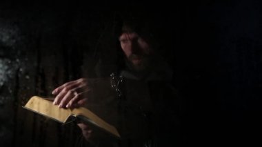 Necromancer mum, şeffaf cam su damlaları karanlık bir arka plan üzerinde kapsadığı arkasında kalın antik kitaptan büyü atmalarını