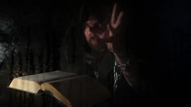 Necromancer mum, şeffaf cam su damlaları karanlık bir arka plan üzerinde kapsadığı arkasında kalın antik kitaptan büyü atmalarını