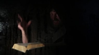 Necromancer mum, şeffaf cam su damlaları karanlık bir arka plan üzerinde kapsadığı arkasında kalın antik kitaptan büyü atmalarını