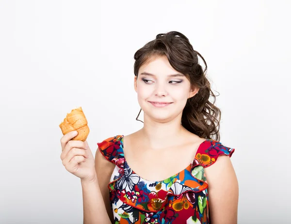 Young smile girl holding and biting bread roll — Stockfoto