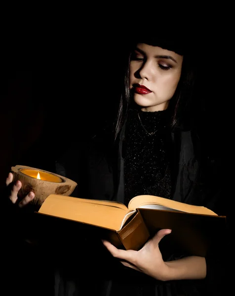 Hermosa bruja joven con un libro de hechizos —  Fotos de Stock