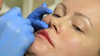 Kalıcı makyaj uygulayarak güzellik uzmanı. Kozmetik Dövme onu dudaklarından sahip genç güzel kadın. Sağlıklı Spa