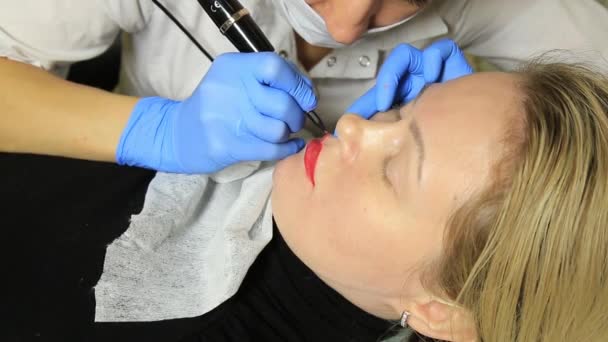 Kosmetolog permanent makeup. Ung vacker kvinna att ha kosmetisk tatuering på hennes läppar. Hälsosam Spa — Stockvideo