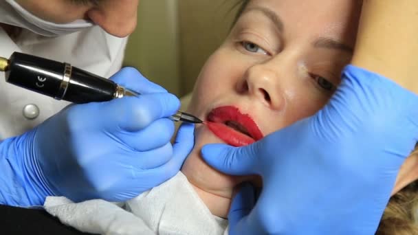 Cosmetologist applying permanent make-up. Young beautiful woman having cosmetic tattoo on her lips. Healthy Spa — Stock Video