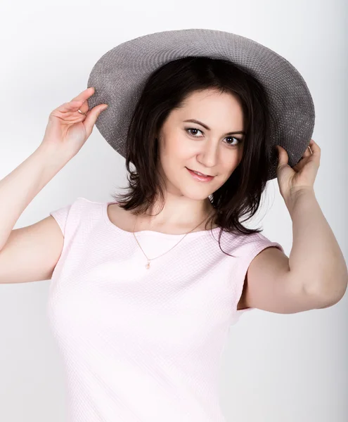 Hermosa joven morena sosteniendo un sombrero de ala ancha, ella expresión de diferentes emociones — Foto de Stock