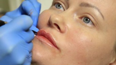 Kalıcı makyaj uygulayarak güzellik uzmanı. Kozmetik Dövme onu dudaklarından sahip genç güzel kadın. Sağlıklı Spa