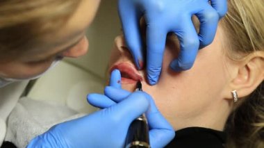 Kalıcı makyaj uygulayarak güzellik uzmanı. Kozmetik Dövme onu dudaklarından sahip genç güzel kadın. Sağlıklı Spa