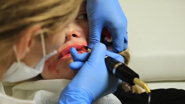 Kosmetikerin, die Permanent Make-up aufträgt. junge schöne Frau mit kosmetischen Tätowierungen auf den Lippen. Gesunder Kurort — Stockvideo