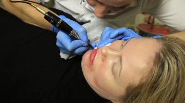 Kalıcı makyaj uygulayarak güzellik uzmanı. Kozmetik Dövme onu dudaklarından sahip genç güzel kadın. Sağlıklı Spa