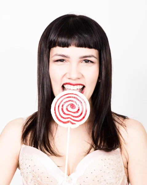 Porträt einer glücklichen schönen jungen Frau, die süße Bonbons leckt und verschiedene Emotionen ausdrückt — Stockfoto