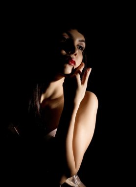 Yakın çekim güzel seksi genç çıplak kadın siyah arka plan üzerine. ışık ve gölge kavramı