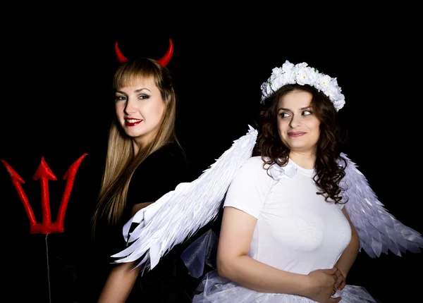 Portrait of angel and devil womans on a dark background