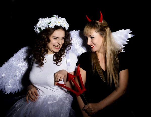 Portrait of angel and devil womans on a dark background