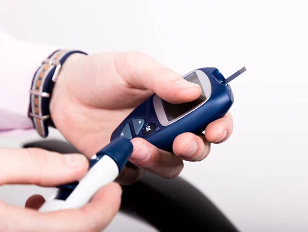 Medir el nivel de glucosa en la sangre usando un ultra mini glucosímetro y una pequeña gota de sangre de las tiras de los dedos y las pruebas. Paciente dependiente con diabetes de primer tipo . — Foto de Stock