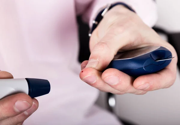 Medir el nivel de glucosa en la sangre usando un ultra mini glucosímetro y una pequeña gota de sangre de las tiras de los dedos y las pruebas. Paciente dependiente con diabetes de primer tipo . — Foto de Stock