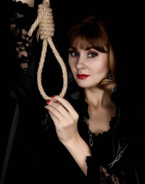 Misteriosa joven mujer sosteniendo lazo de la cuerda. sobre un fondo oscuro — Foto de Stock