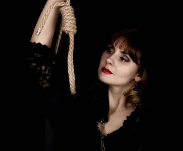 Таинственная молодая женщина держит петлю на веревке. на темном фоне — стоковое фото