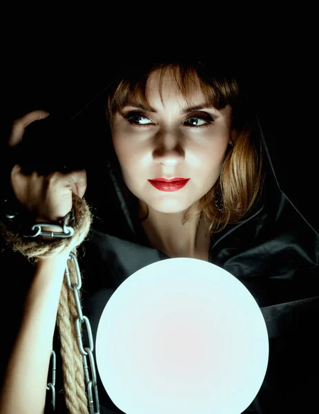 Misteriosa mujer joven sosteniendo lazo de la cuerda y gran bola brillante. sobre un fondo oscuro — Foto de Stock