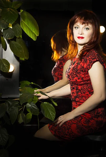 Retrato de uma bela mulher ruiva sentada perto do espelho — Fotografia de Stock