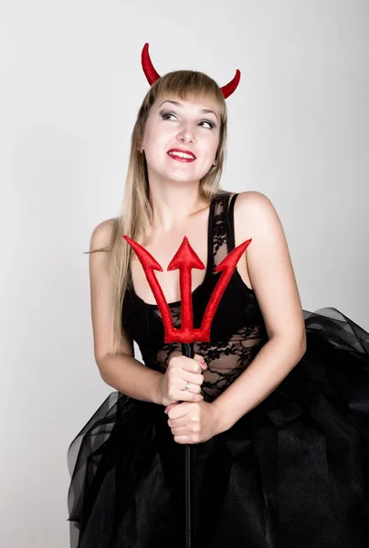 Bella giovane donna indossa un costume sexy diavolo con un tridente — Foto Stock