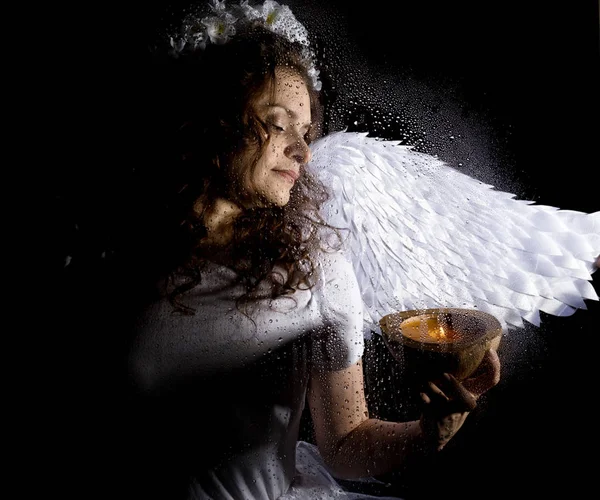 Πορτρέτο του γυναικείου άγγελος και διάβολος σε σκούρο φόντο, πίσω από διαφανές γυαλί που καλύπτεται από σταγόνες νερού. — Φωτογραφία Αρχείου