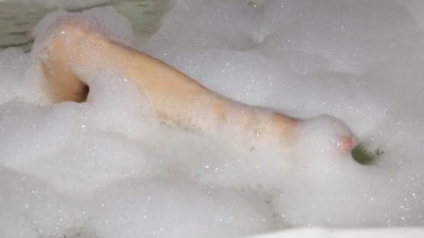 Giovane donna godendo piacevole bagno con schiuma, primo piano lavarsi le gambe — Video Stock