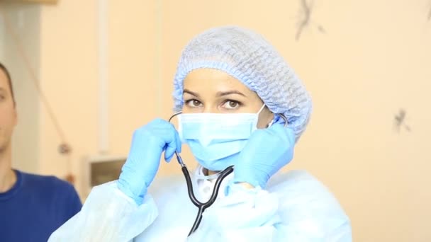 Femme médecin tenant stéthoscope et examine patient — Video