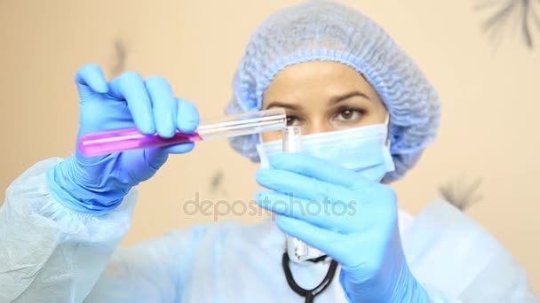 Женщина-врач в медицинской форме держит пробирку — стоковое видео