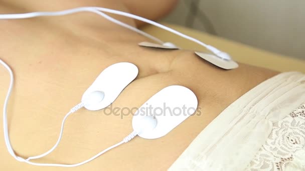 Профессиональная электротерапия женского тела. мышечное сокращение под воздействием электрического тока. крупным планом желудок — стоковое видео
