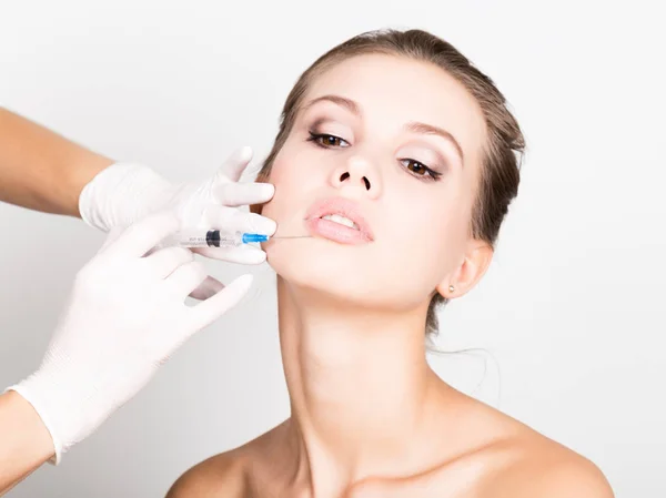 Närbild av vacker ung kvinna får injektion i ögonen och läpparna från kosmetolog. bevarandet av skönhet koncept — Stockfoto