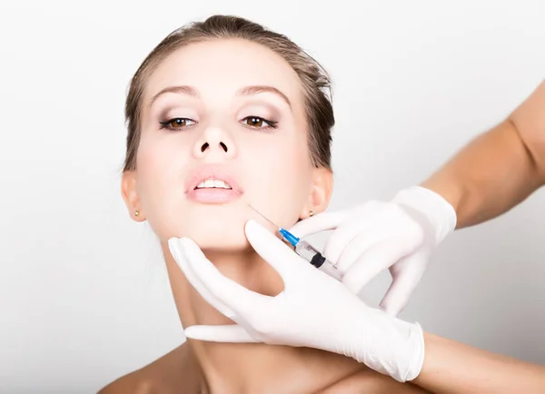 Közelkép a gyönyörű fiatal nő kap injekció a szem és az ajkak terület kozmetikus. megőrzése a szépség fogalma — Stock Fotó
