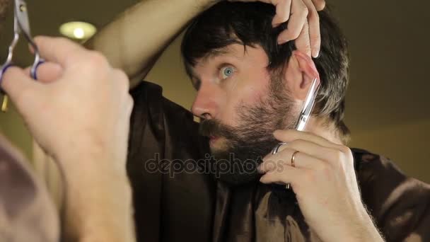 Közeli fiatal jóképű férfi tisztítás szakáll ollóval. Fiatal ember dolgozik a szakállát, és fésű, olló stílus szépségszalon. — Stock videók