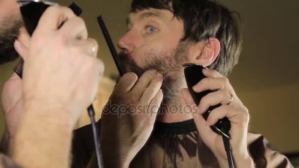 Joven hombre guapo en salón de belleza trabajando en su barba y peinado con peine y peluquero . — Vídeos de Stock