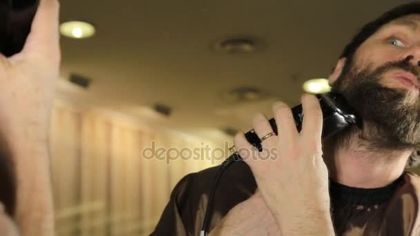 Joven hombre guapo en salón de belleza trabajando en su barba y peinado con peine y peluquero . — Vídeos de Stock