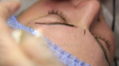 Kalıcı makyaj uygulayarak güzellik uzmanı. Eski güzel kadın kozmetik dövme onun kaş üzerinde sahip. Kadınlar için Güzellik Salonu. Kozmetik Dövme.