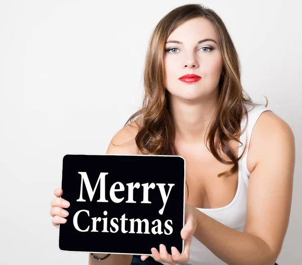 Feliz cristmas escrito na tela virtual. mulher bonita com ombros nus segurando tablet pc. conceito de tecnologia, internet e rede . — Fotografia de Stock
