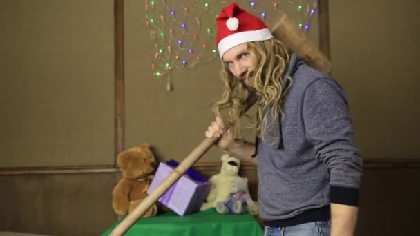 Evil dwarf or bad santa gifts guards with a wooden mallet — Stock Video