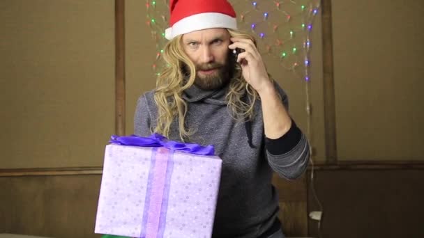 Evil dwarf or bad santa holding a gift in celebratory packing — Stock Video