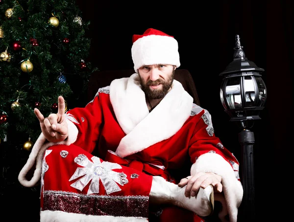 Cattivo rastoman Babbo Natale facendo diversi segni di dita sullo sfondo dell'albero di Natale — Foto Stock