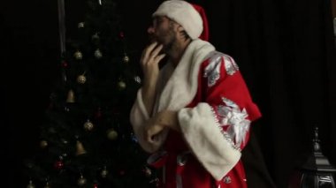 kötü acımasız gülümseyen ve komik dans, Noel ağacı arka plan üzerinde Noel