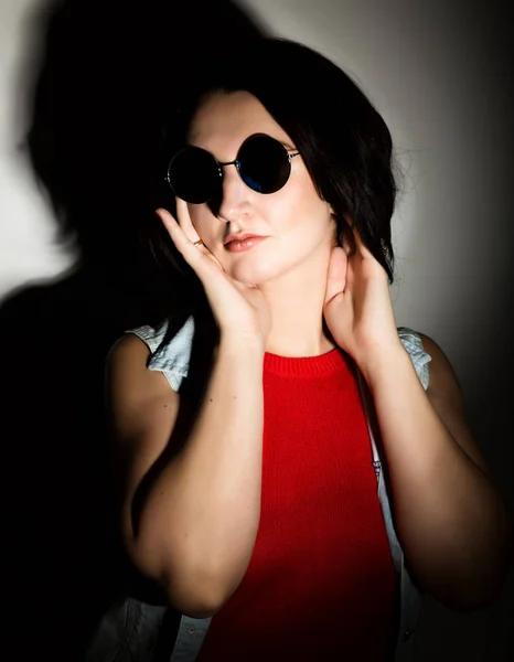 Gyönyörű fiatal nő, fekete kerek napszemüveg. Megható szemüveg. — Stock Fotó