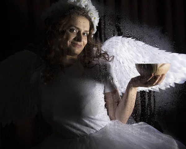 Retrato de ángel y diablo sobre un fondo oscuro, detrás de vidrio transparente cubierto por gotas de agua . — Foto de Stock