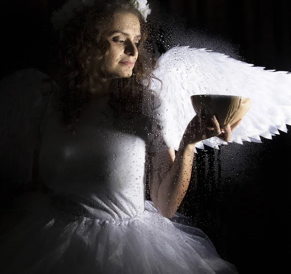 Retrato de ángel y diablo sobre un fondo oscuro, detrás de vidrio transparente cubierto por gotas de agua . — Foto de Stock