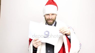 işadamı ile bir takım elbise Noel Baba bir parça kağıt numaraları ile tutar. son geri sayım