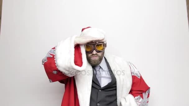 Hombre de negocios en un traje de Santa Claus levantó la mano a sus ojos y mira a la distancia — Vídeos de Stock