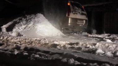 Karda araba sıkışmış. Araçların hareketi felç. Sürücü yolda kar temizler