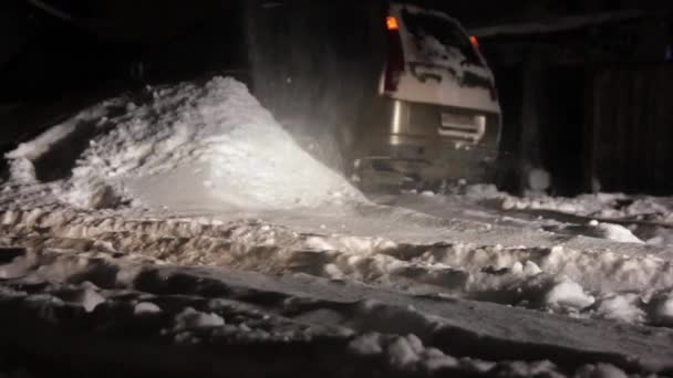 Auto steckt im Schnee fest. lähmte den Fahrzeugverkehr. Fahrer reinigt Straße von Schnee — Stockvideo