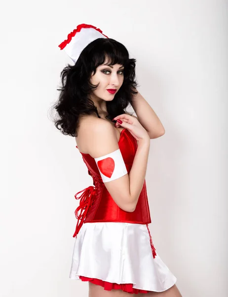 Mooie jongedame, gekleed als verpleegkundige, medische carnaval kostuum, ze houden van een stethoscoop — Stockfoto